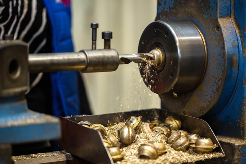 Steel machining process with a drill bit on a metal workpiece.