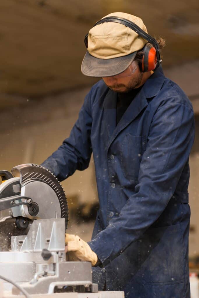 Steel fabrication worker using a cutting machine in a workshop.